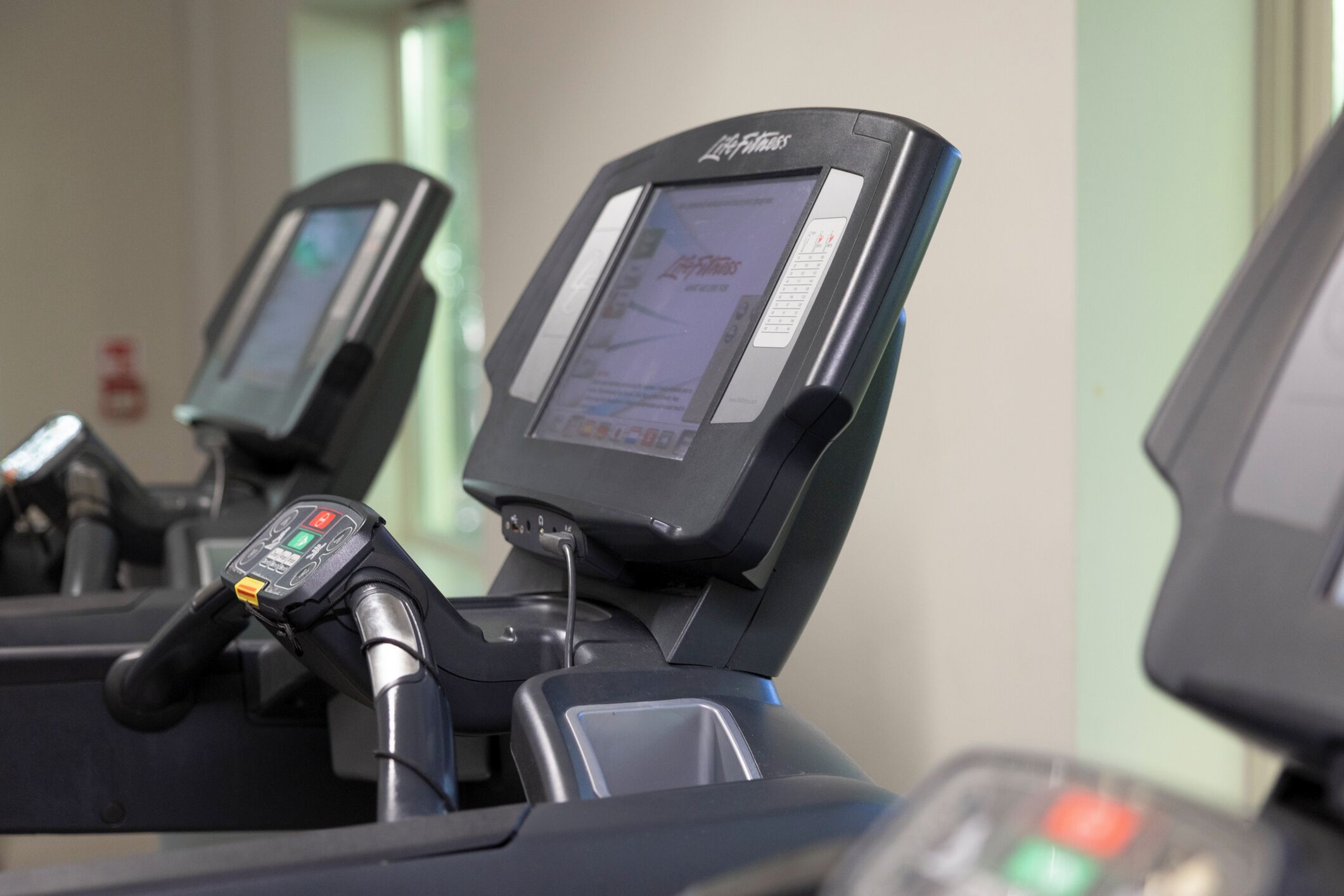 A treadmill with a digital display and control panel.