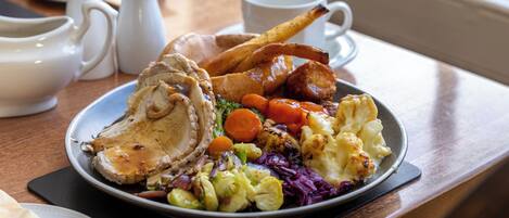 A plate of food with roasted meat, vegetables, and gravy.