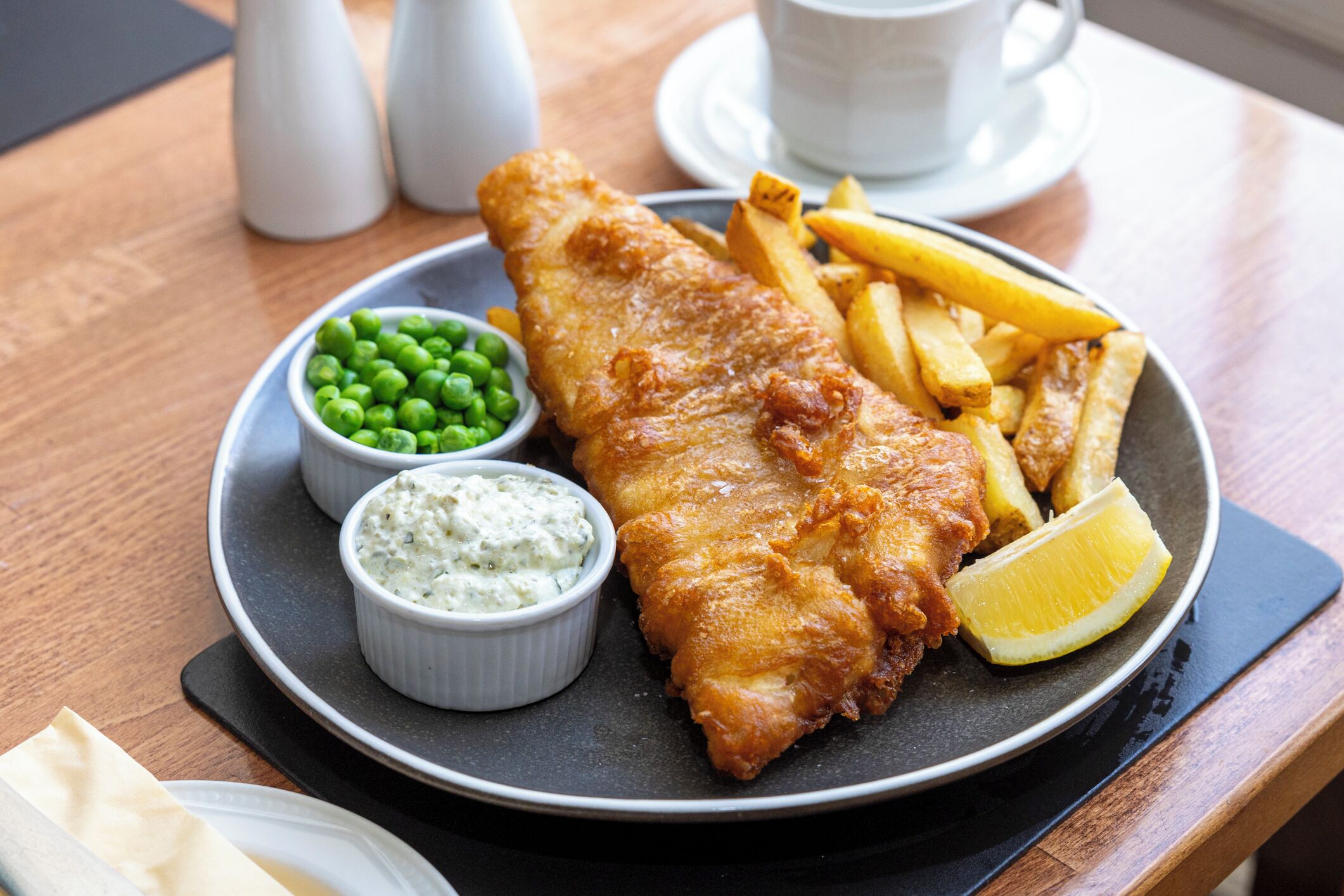 Ein Teller Fish and Chips mit Erbsen und Remoulade.