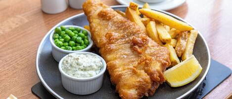 Ein Teller Fish and Chips mit Erbsen und Remoulade.