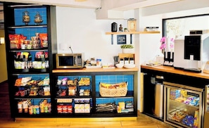 A snack bar with shelves stocked with various snacks and a coffee machine. - ARC Hotel, Washington DC, Series by Marriott (Washington)