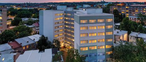 A multi-story building with a flat roof and a central entrance.