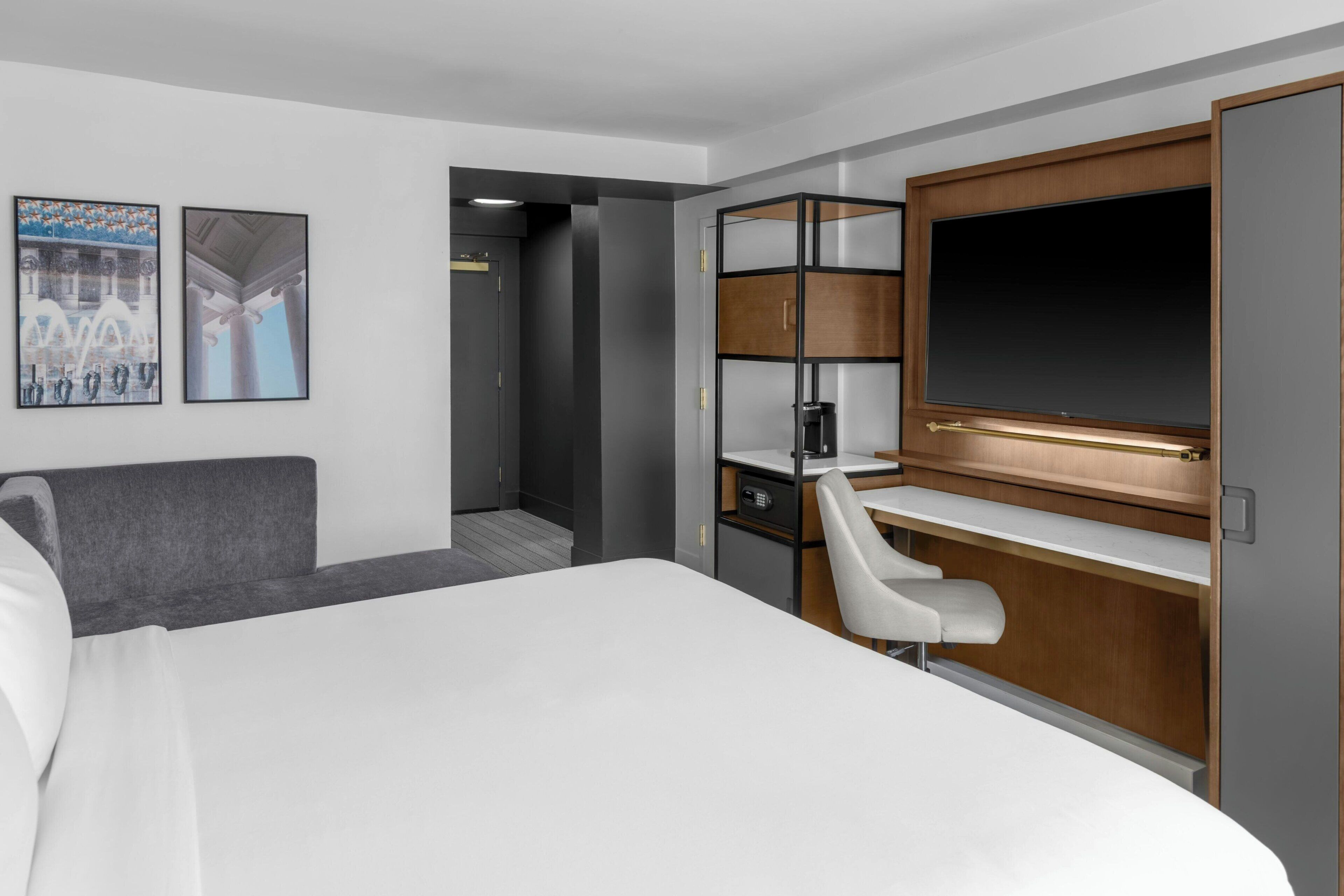 Une chambre d’hôtel équipée d’un lit, d’un bureau, d’une chaise, d’une télévision et d’une armoire.