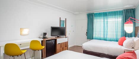A hotel room with two beds, a desk with a television, and yellow chairs.