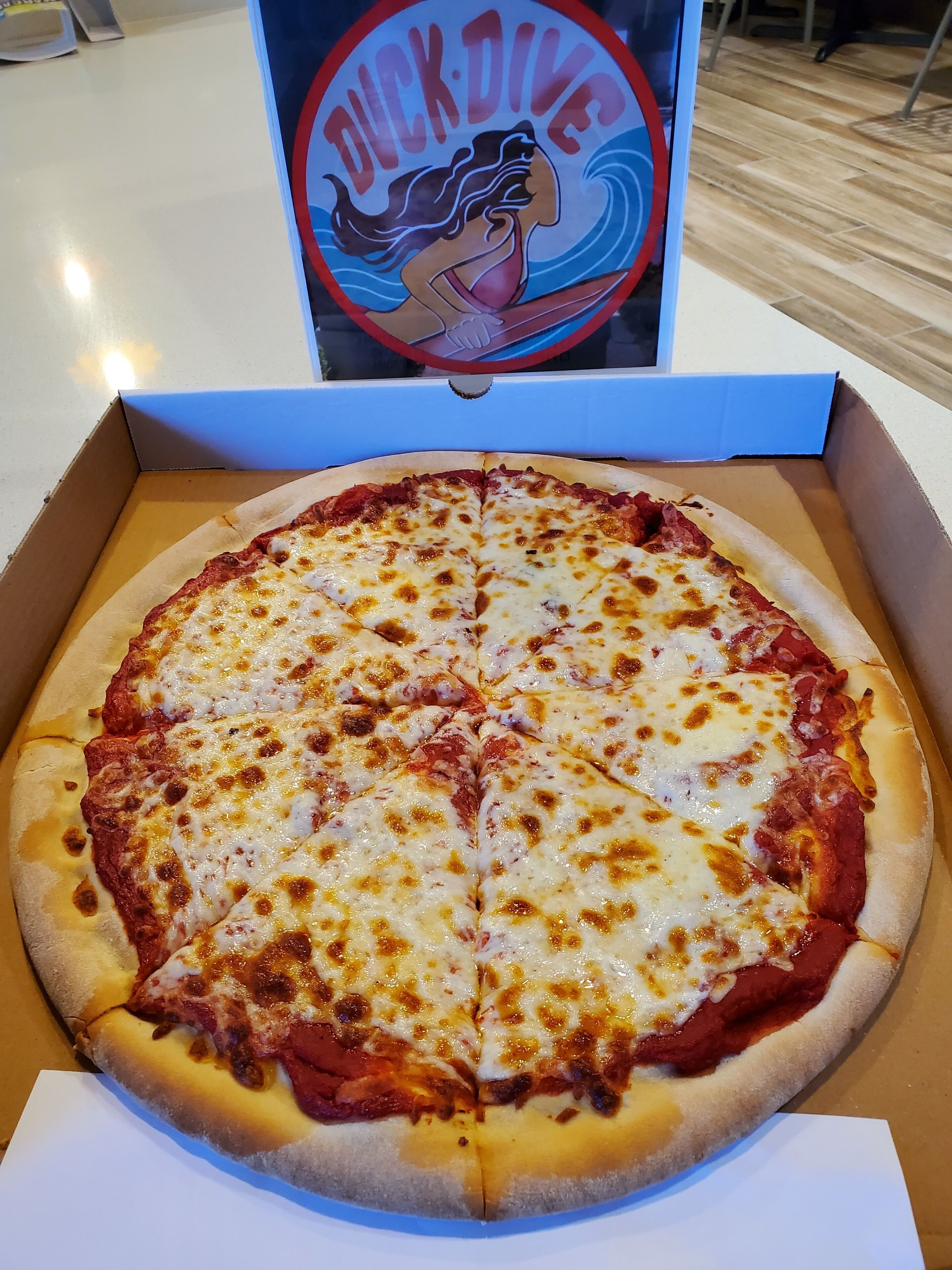 Une pizza dans une boîte, avec un logo au-dessus.