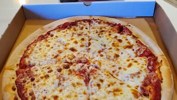 Une pizza dans une boîte, avec un logo au-dessus.