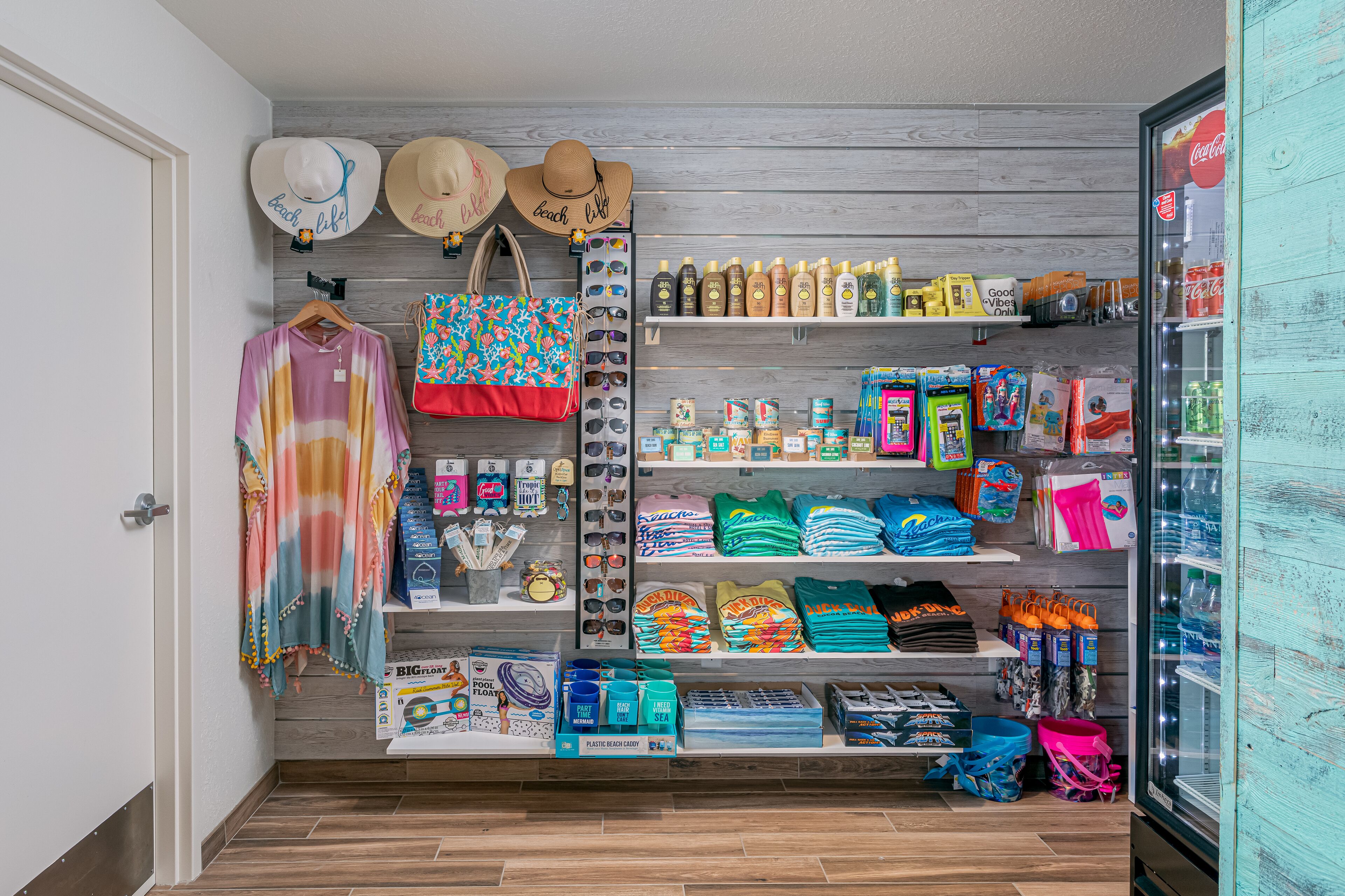 Un espacio comercial con temática playera, que ofrece sombreros, gafas de sol y ropa de playa.