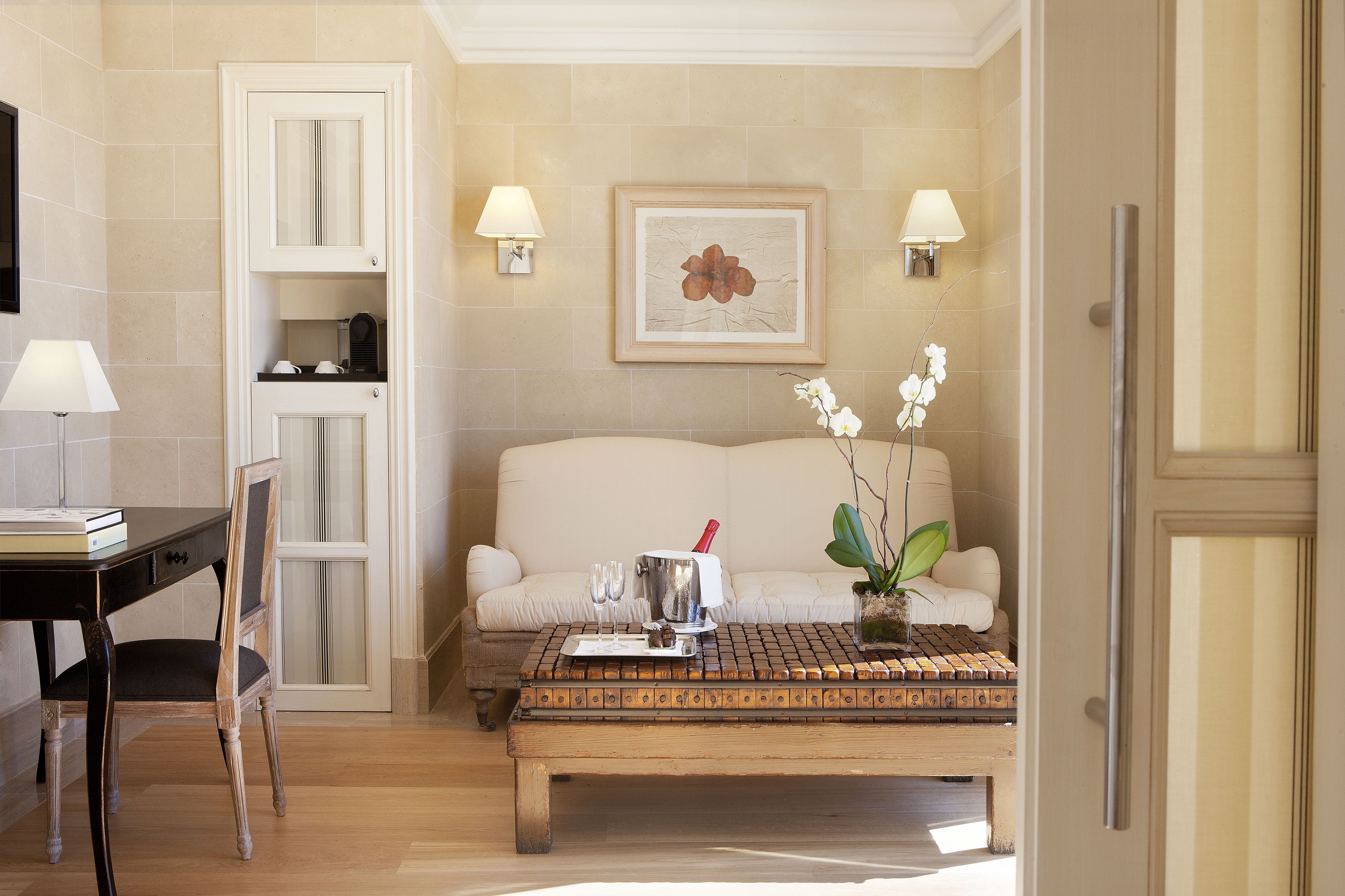 Una habitación con una mesa de comedor, un sofá, una mesa baja, una silla, una lámpara y un cuadro en la pared.