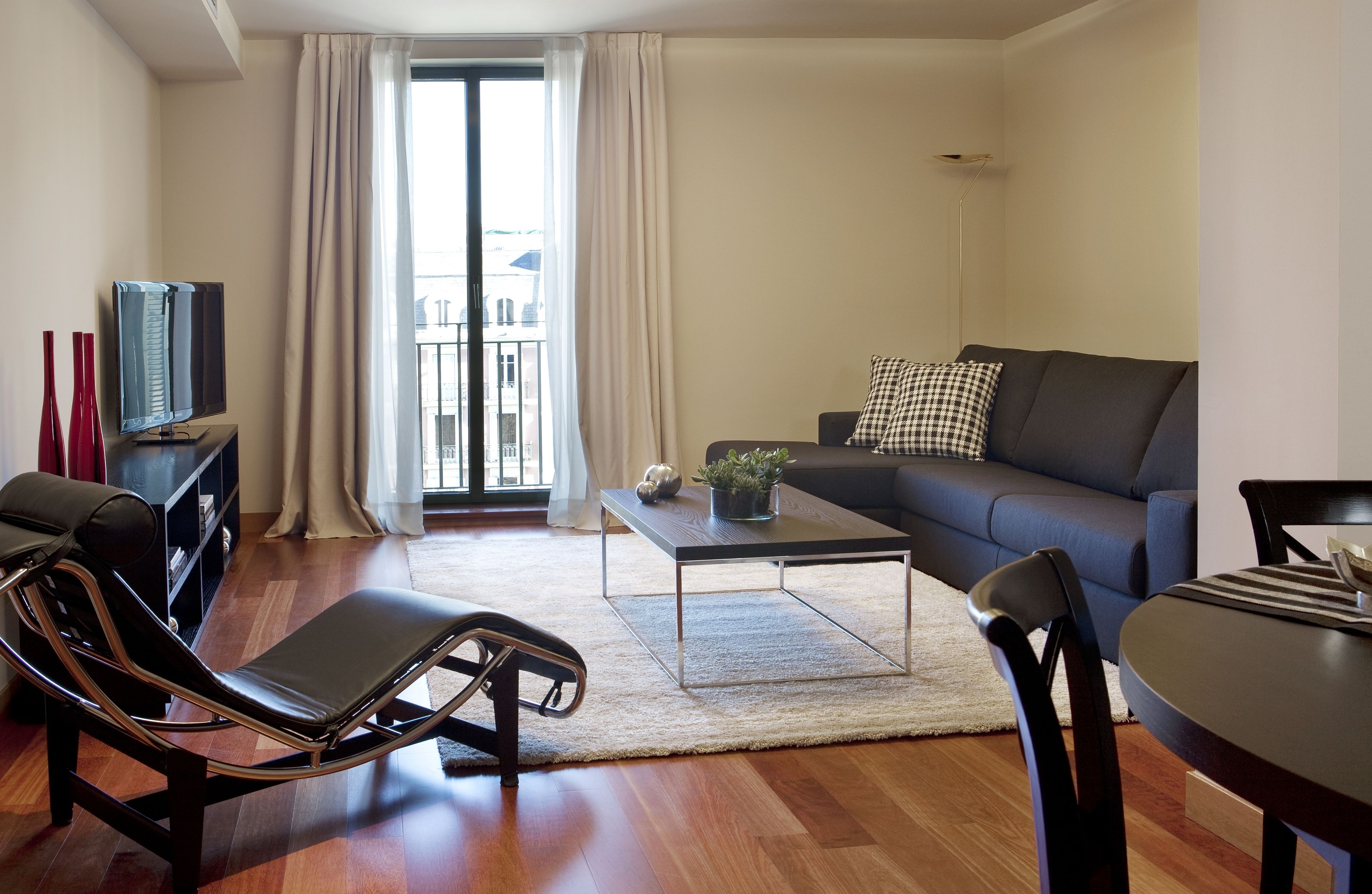 A modern living room with a sofa, a coffee table, a TV, and a chair.