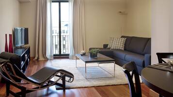 Una sala moderna con un sofá, una mesa de centro, un televisor y una silla.