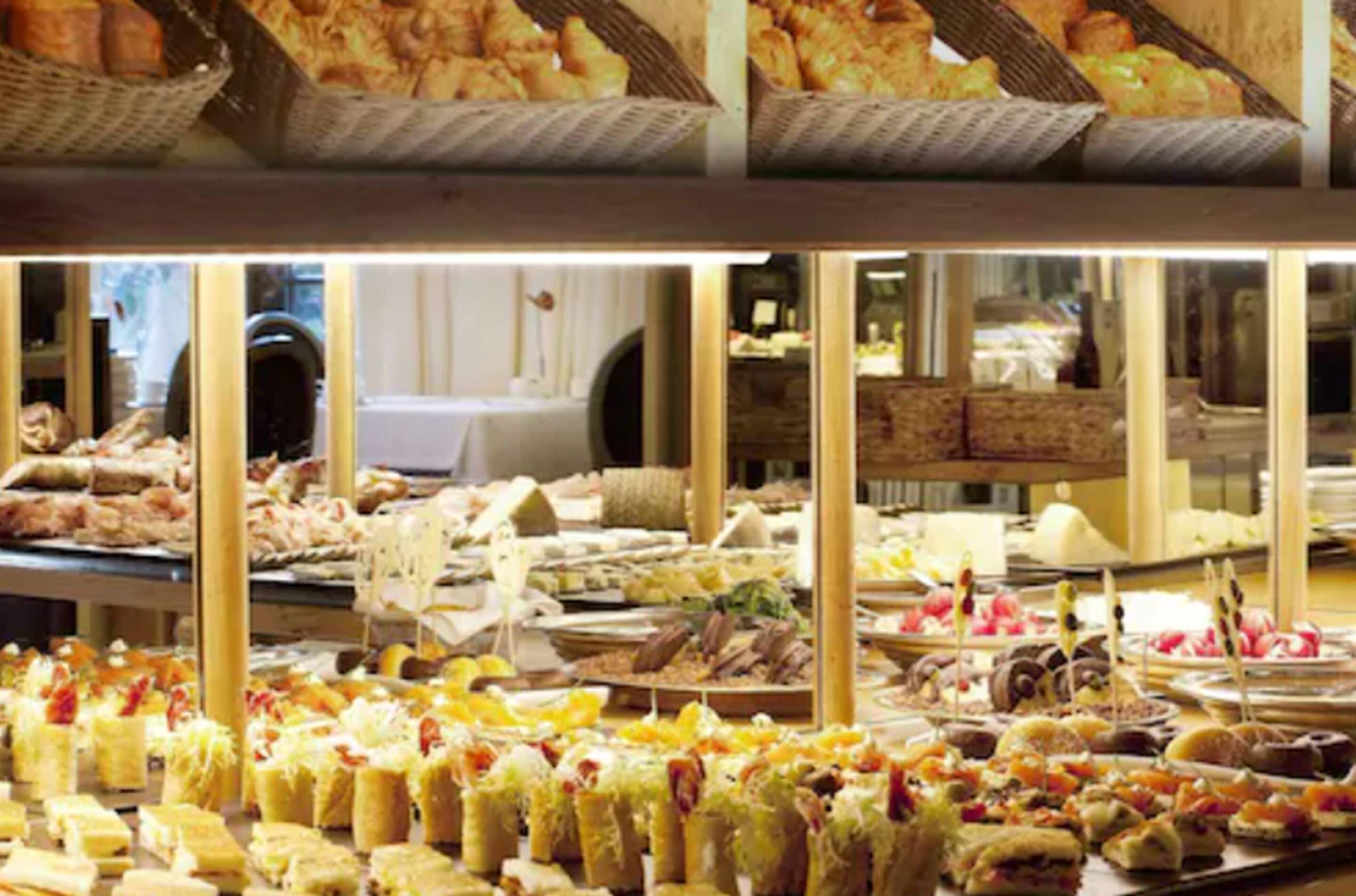 Un buffet proposant une variété de plats et un espace repas avec des tables et des chaises.