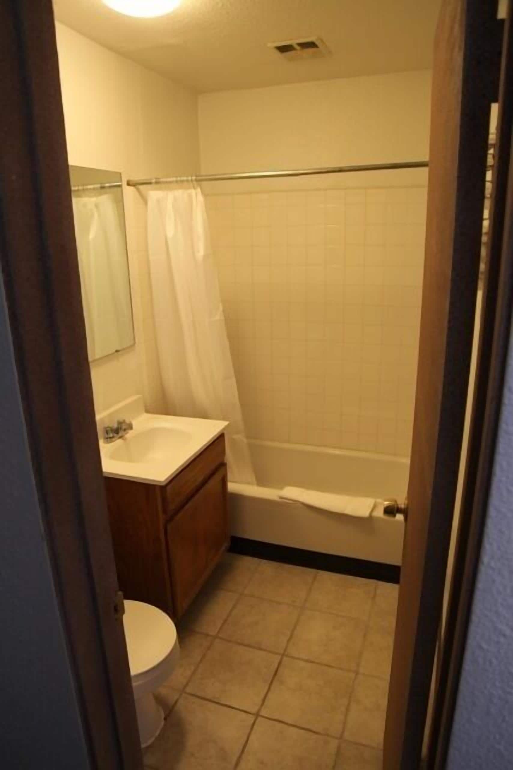 A small bathroom with a toilet, sink, and bathtub.