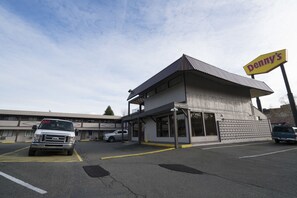 A building with a sign reading "Denny's" and a parking lot with vehicles. - Seatac Inn (SeaTac)