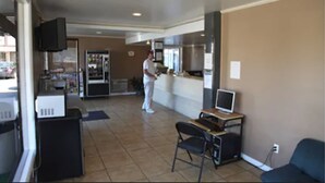 Un restaurante con mostrador, refrigerador, televisor y computadora.
