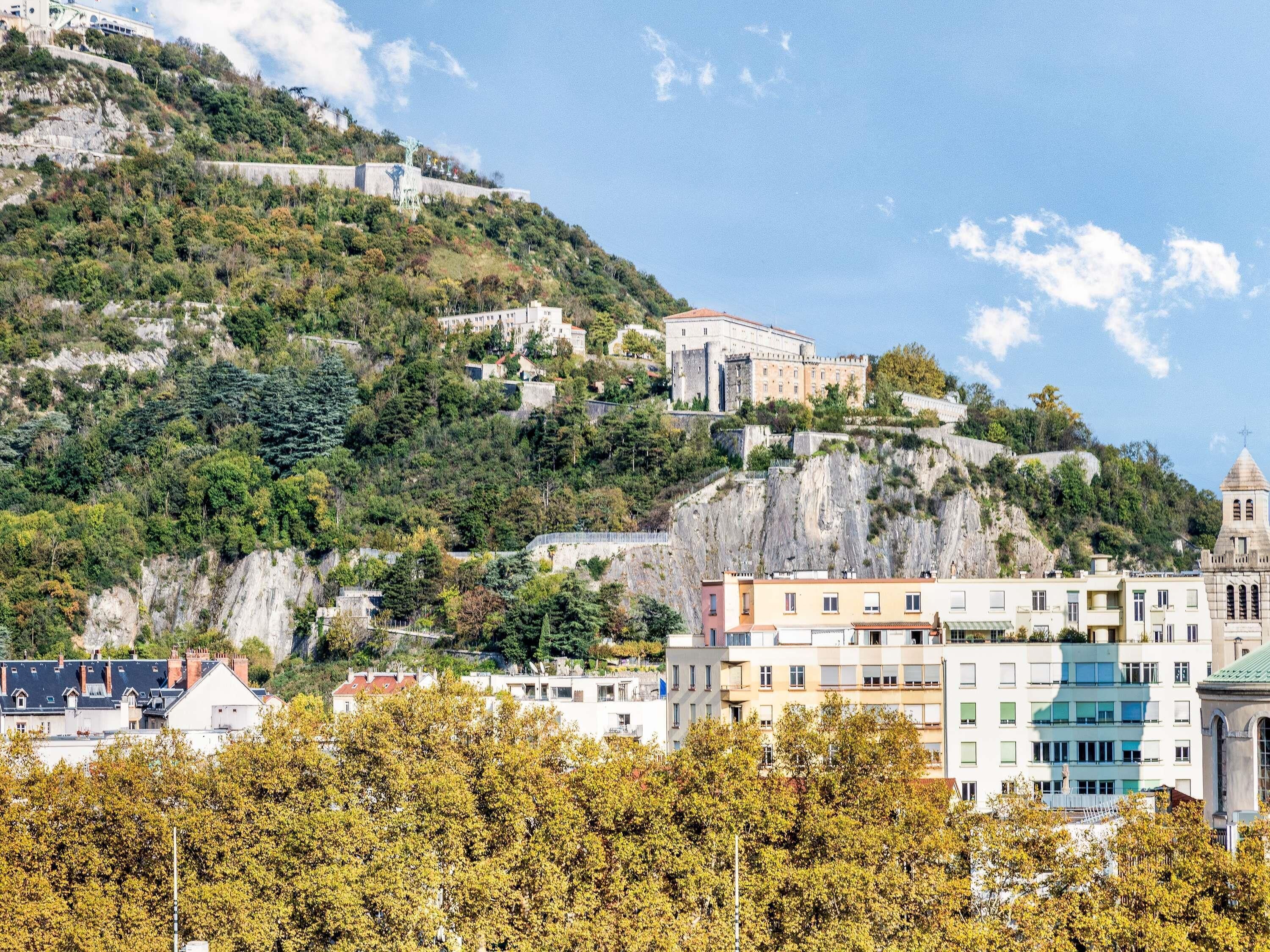 A hillside with buildings, including a prominent white structure with a dome.