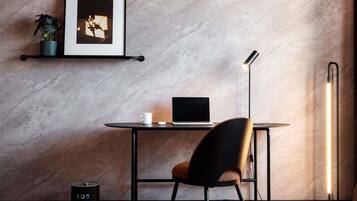 Un espacio de trabajo moderno con escritorio, silla, ordenador portátil y lámpara de pie.