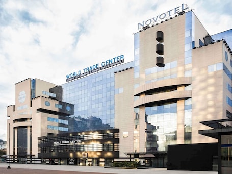 A modern building with the sign 'World Trade Center' and 'Novotel' on the facade.. Novotel Grenoble Centre