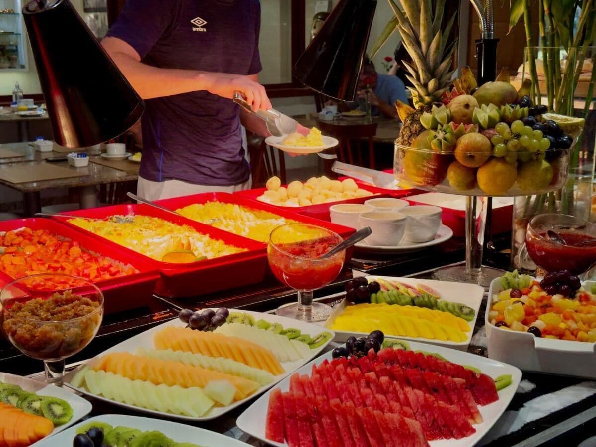 Un bufé con una variedad de alimentos, entre ellos frutas, verduras y postres.