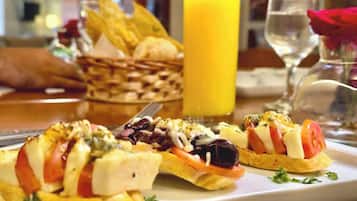 Um prato de comida com um copo de suco de laranja e uma cesta de pão.