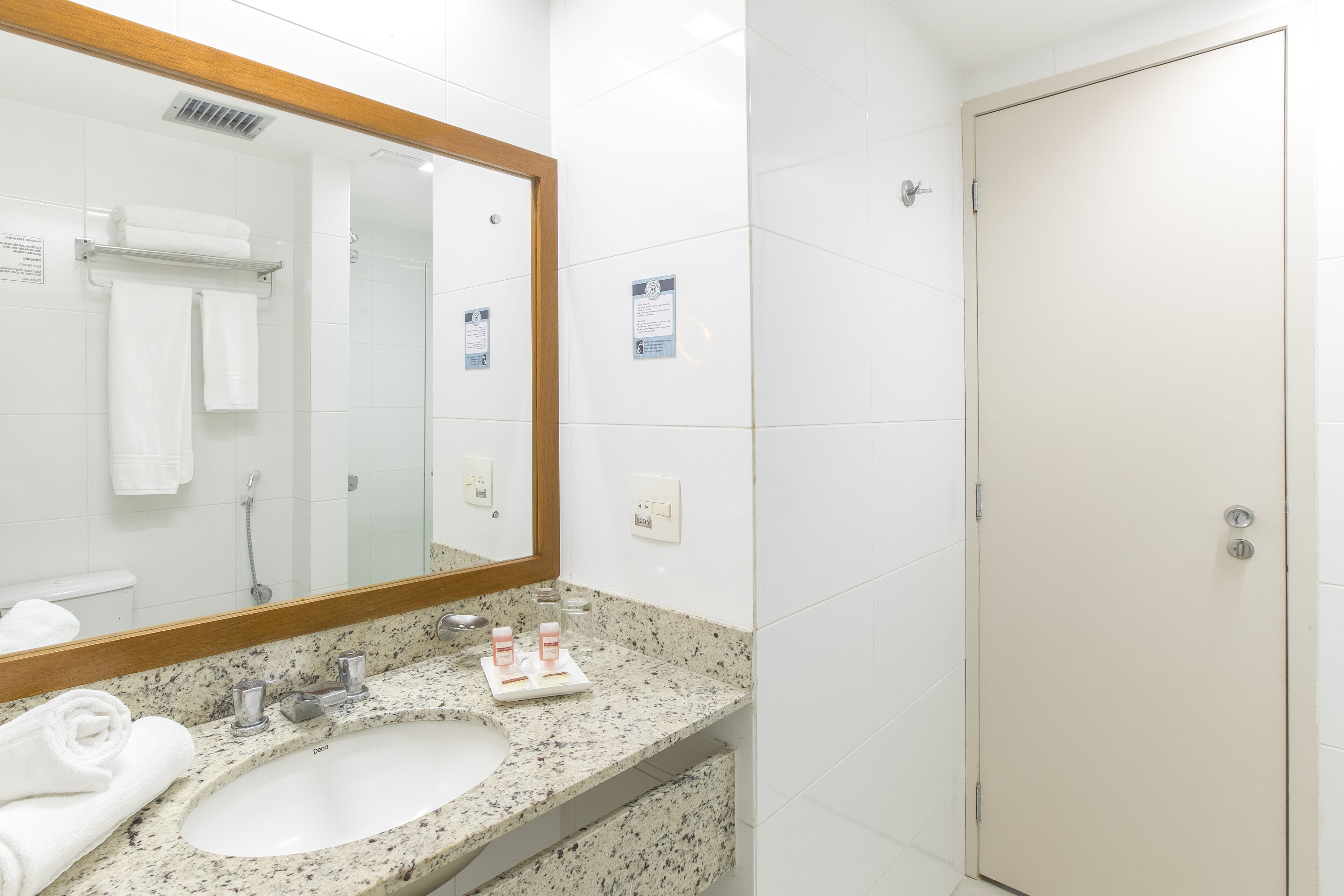 A bathroom with a sink, mirror, and towel rack.
