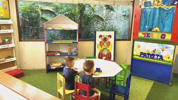 Children can play and learn in this room with a bookshelf, table, and colorful play structure.