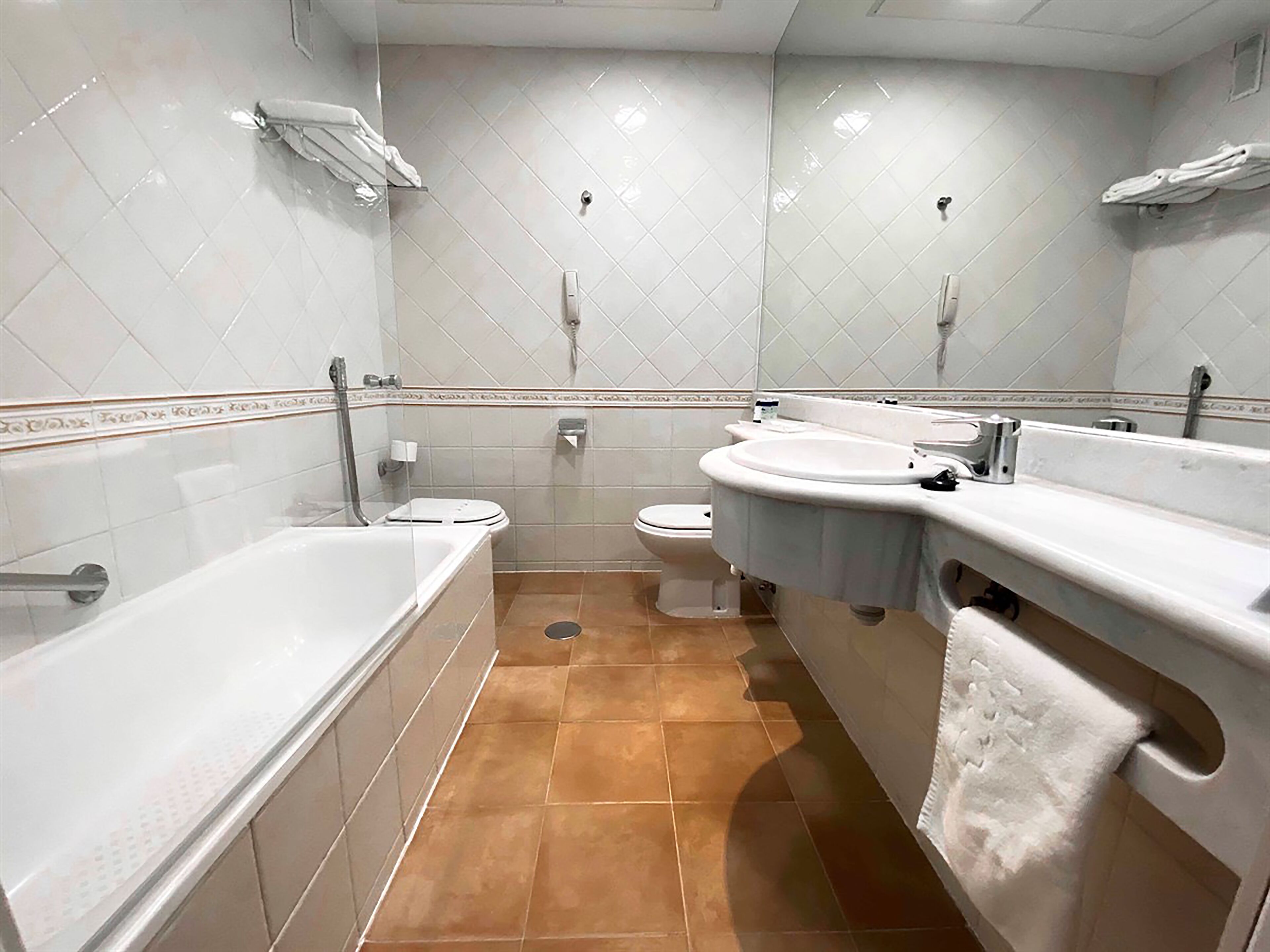 Un baño con bañera, inodoro y lavabo.