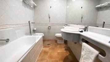 A bathroom with a bathtub, toilet, and sink.