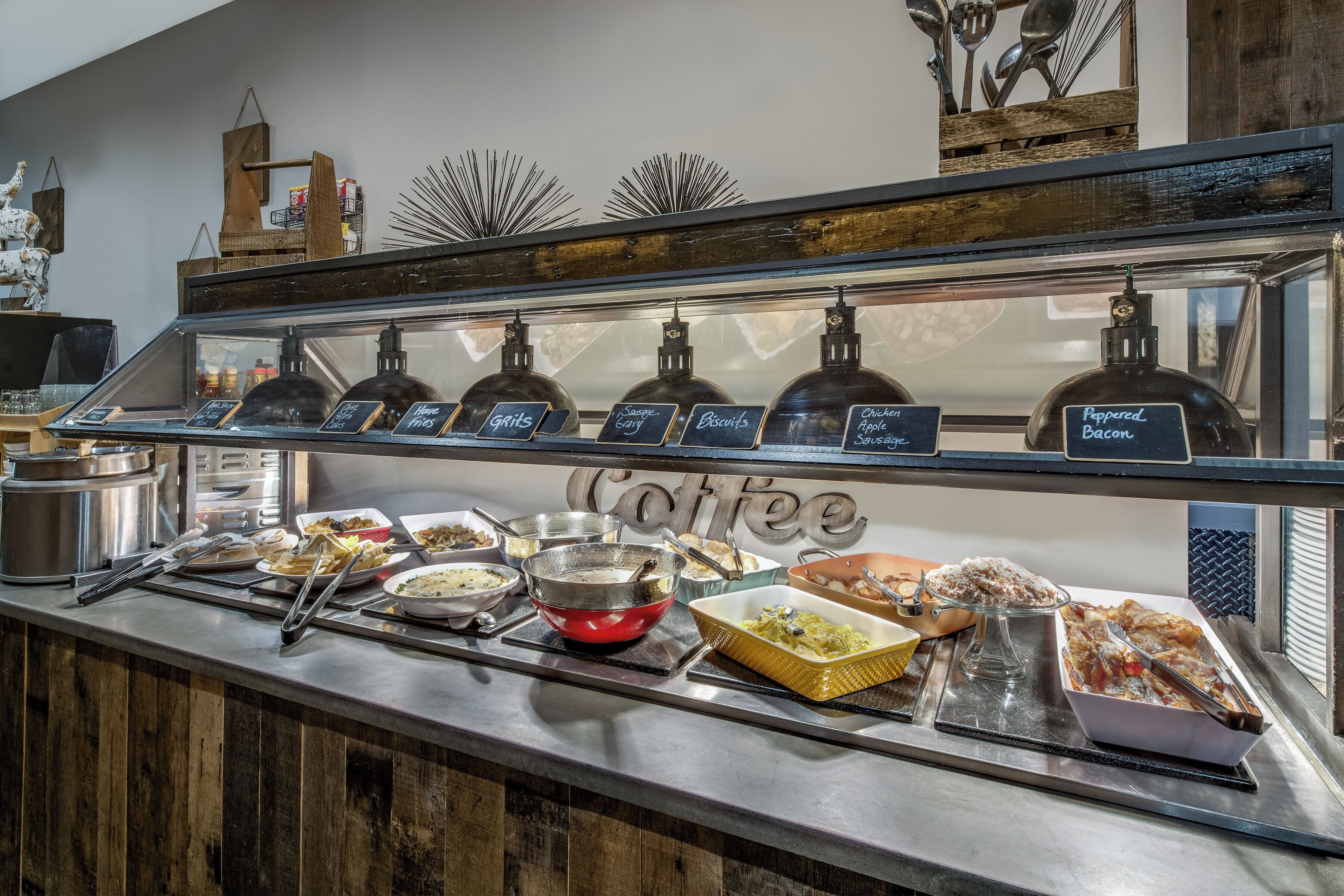 A buffet counter with various food items and condiments.