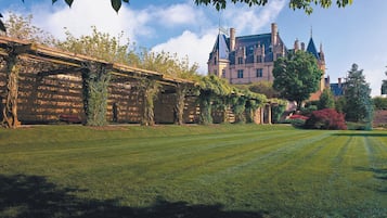 A well-manicured lawn with a large, ornate building in the background.