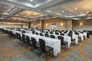 A large conference room with rows of tables and chairs, equipped with chandeliers and wall sconces. - Crowne Plaza Resort Asheville by IHG (Asheville)