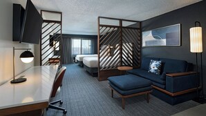 A hotel room with a desk, a sofa, a bed, and a large window. - Courtyard Marriott Laredo (Laredo)