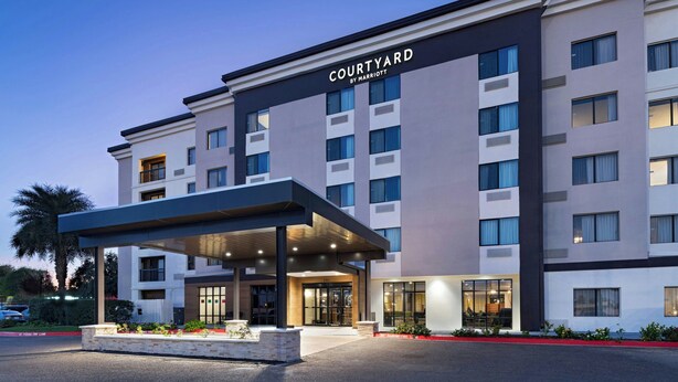 A multi-story hotel with a covered entrance, a sign reading "Courtyard by Marriott," and a landscaped area with plants. - Courtyard Marriott Laredo (Laredo)