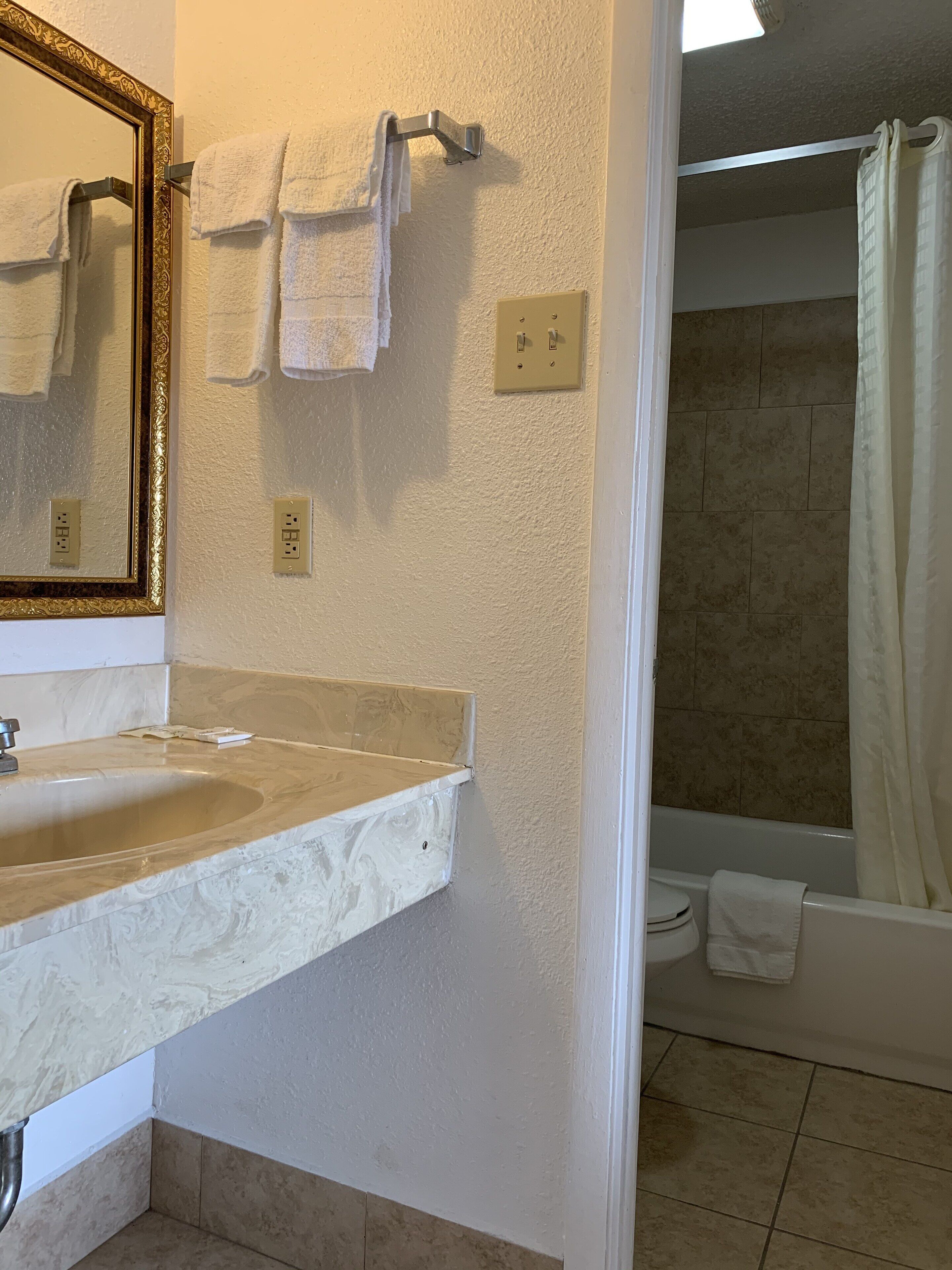 A bathroom with a sink, mirror, and towel rack.