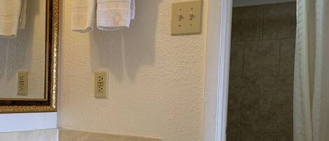 A bathroom with a sink, mirror, and towel rack.