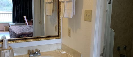 Baño con lavamanos, espejo e inodoro.