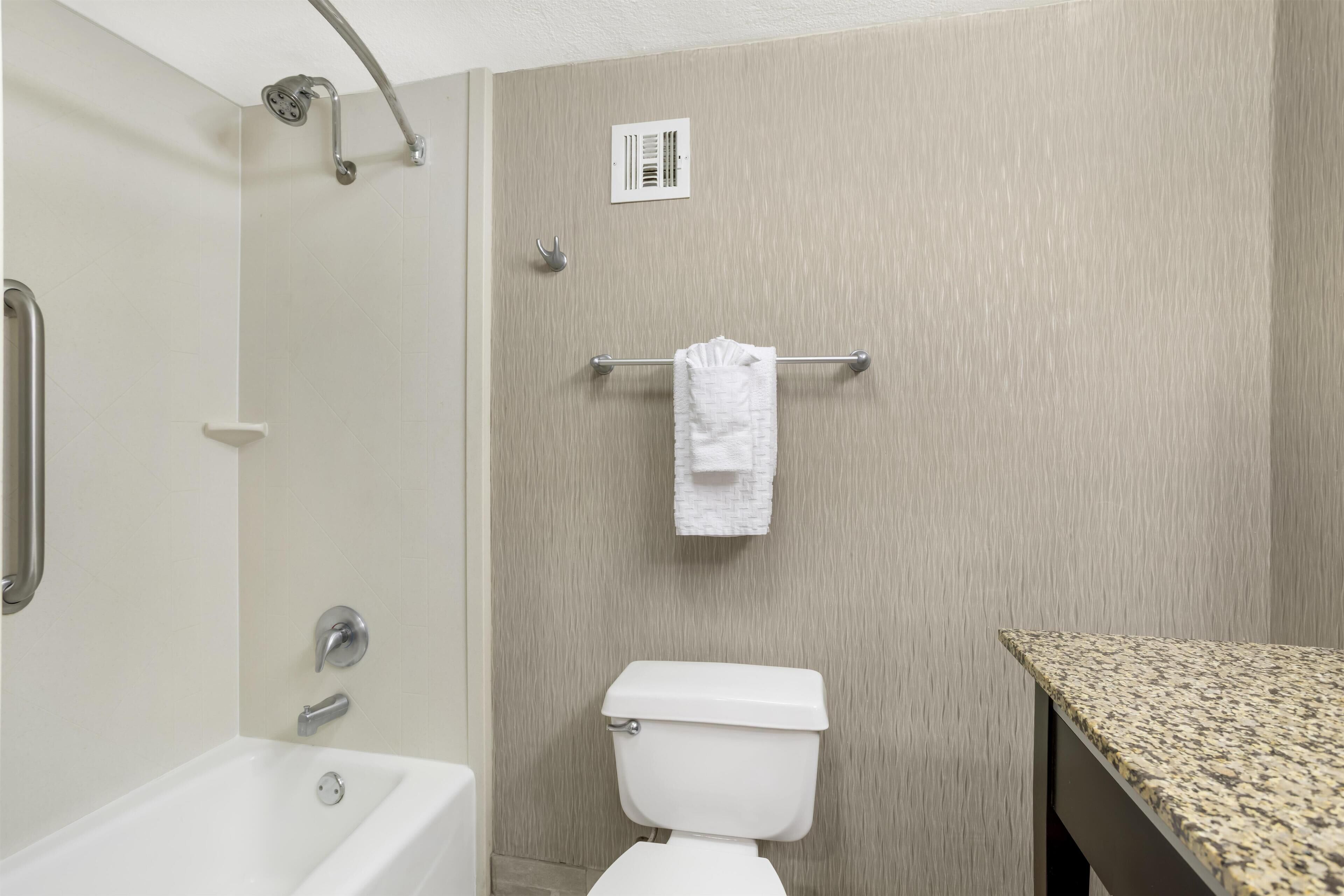 A bathroom with a bathtub, toilet, and shower.
