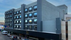 A modern building with a flat facade, multiple windows, and a ground-level entrance. - Hotel Chihuahua San Francisco (Chihuahua)