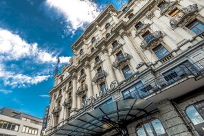 A historic hotel with ornate architecture, a prominent entrance canopy, and a clear view of the sky.
