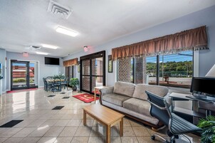 A spacious lobby with a sofa, a coffee table, a TV, and a computer desk.