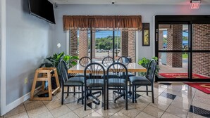 Un comedor con pared de ladrillo, un ventanal y vista al estacionamiento.