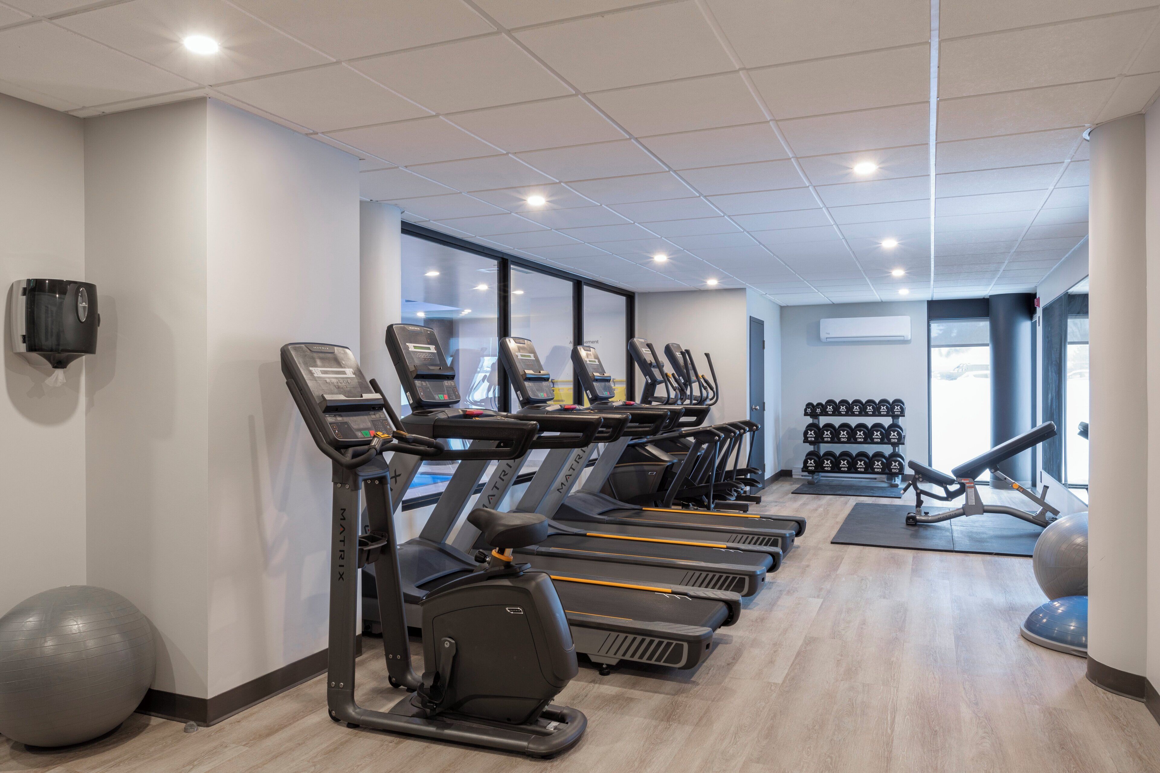 Ein Fitnessstudio mit Laufbändern, Gymbällen und Kurzhanteln.