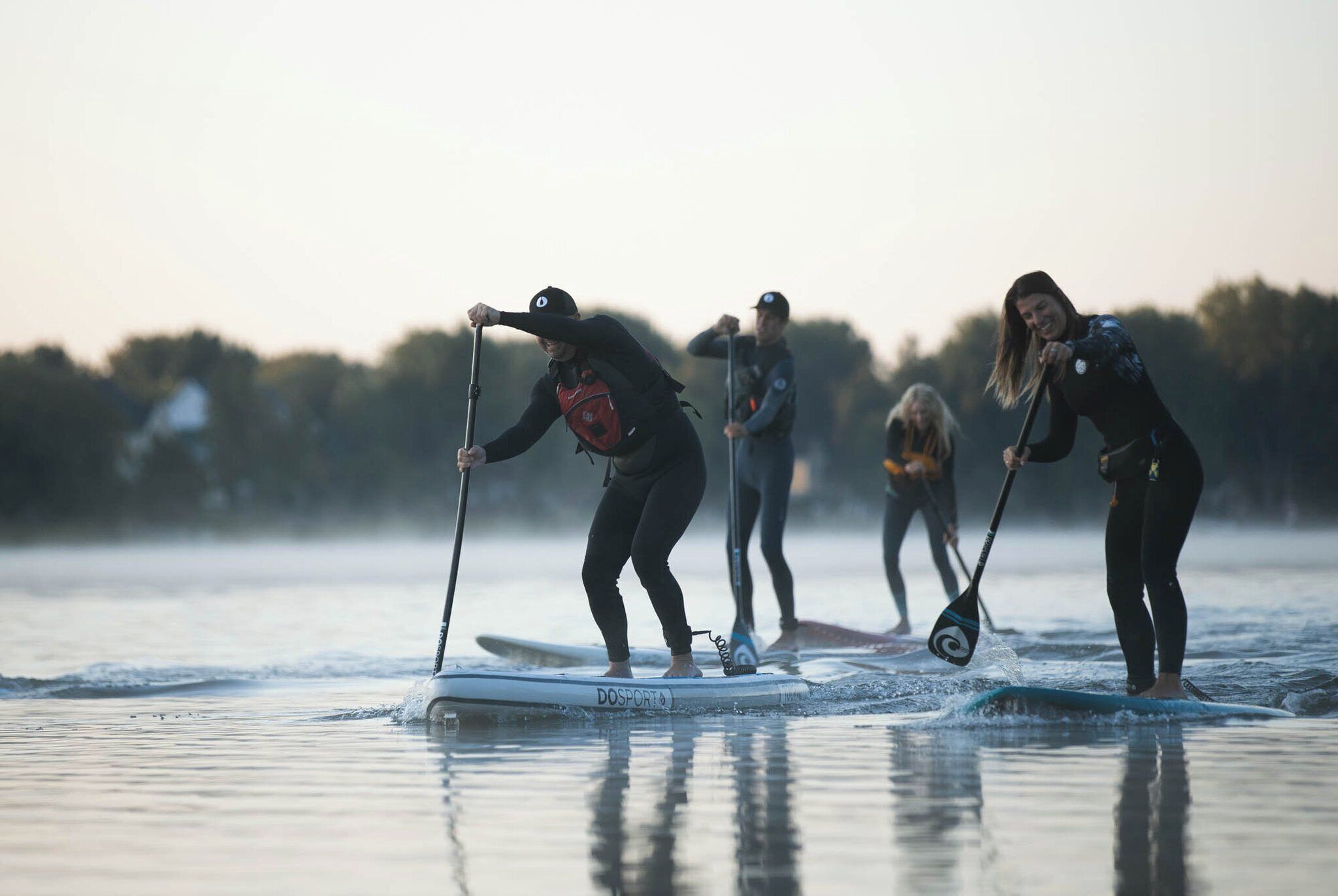 People paddleboarding on a calm body of water.