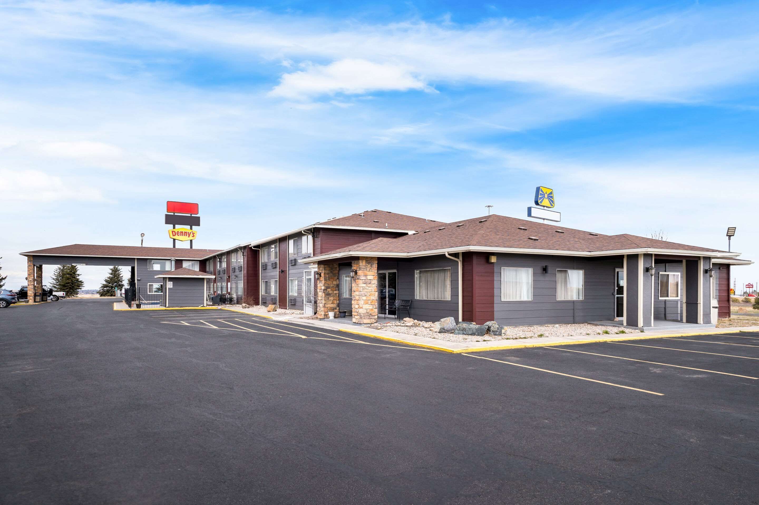A motel with a parking lot, a visible sign for 'Penny's', and a gas station sign in the background.