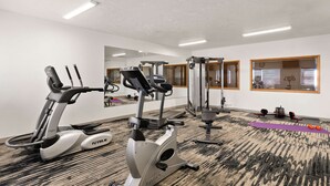 A gym with cardio machines, weightlifting equipment, and a yoga mat. - Quality Inn Cheyenne I-25 South (Cheyenne)