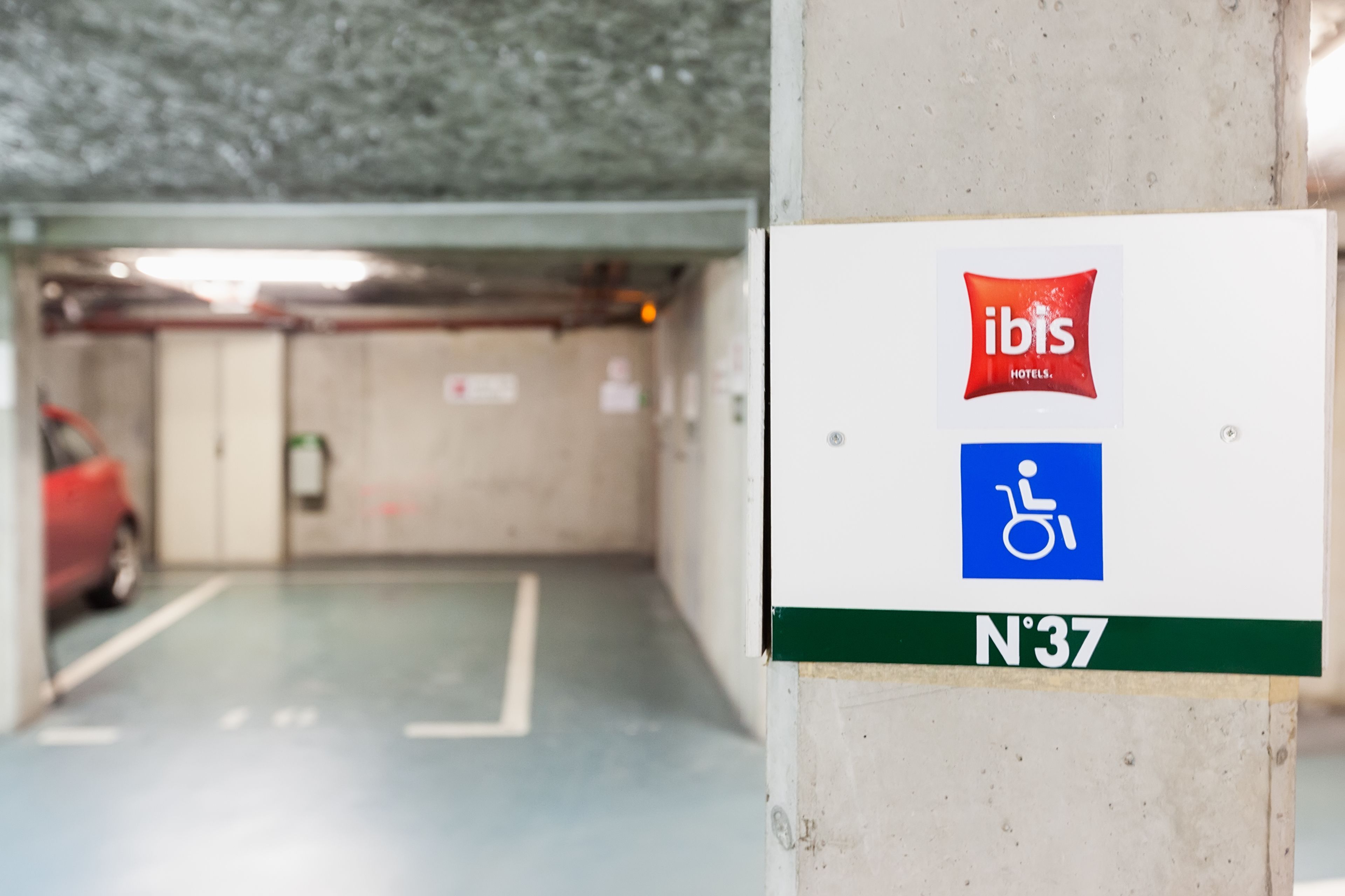 Señal de estacionamiento para hoteles ibis con símbolo de accesibilidad para sillas de ruedas y el número N37.
