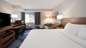 A hotel room with a large bed, a desk with a chair, a television, and a window with curtains. - Fairfield Inn By Marriott Amesbury (Amesbury)