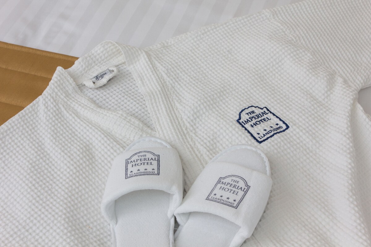 A white towel and slippers with a hotel logo.