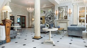 A spacious lobby with a grand chandelier, elegant furniture, and a decorative mirror. - Imperial Hotel (Llandudno)