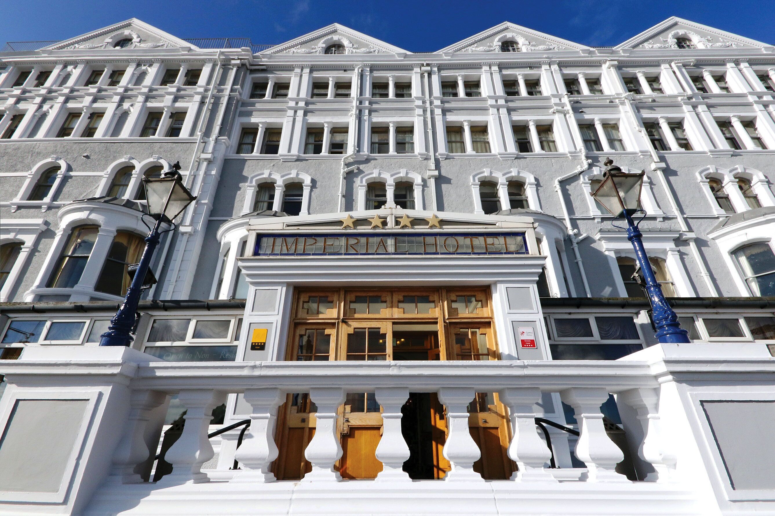 A grand building with a classical architectural style, featuring a prominent entrance with a marquee sign reading "IMPERIAL HOTEL".