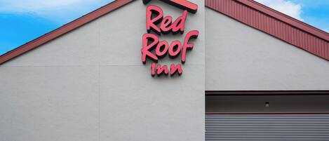 Un edificio con un cartel que dice 'Red Roof Inn' y una puerta de garaje.